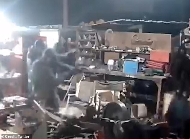 ctured: The would-be robbers are seen holding up weapons, pointing them at the farmer who is just out of shot to the right in this still grab of CCTV footage