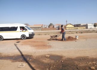 Eric Nsembene gets donations from motorists and taxi drivers for fixing potholes on this busy road in Mamelodi. Photos: Warren Mabona