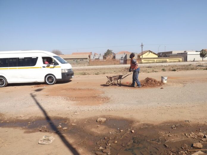 Eric Nsembene gets donations from motorists and taxi drivers for fixing potholes on this busy road in Mamelodi. Photos: Warren Mabona