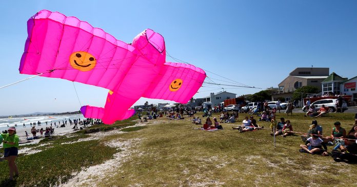 Cape-Town-kite-festival-south-africa A boy looks at a kite during the 28th Cape Town International Kite Festival, an awareness-campaign for World Mental Health Day where kite enthusiasts gather to fly colourful kites, participate in social activities, and raise funds for mental health support at Melkbosstrand, Cape Town, South Africa, October 9, 2022. REUTERS/Esa Alexander