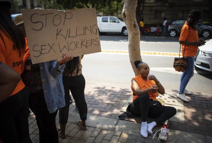 Sex workers and their supporters protest outside the Johannesburg Magistrate’s Court during the first appearance of a man accused of killing six women. EPA-EFE/Kim Ludbrook