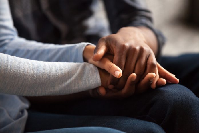 Close up black male and female holds hands Police Investigating Tragic Death of Disabled 12-Year-Old Kept in KZN Backyard