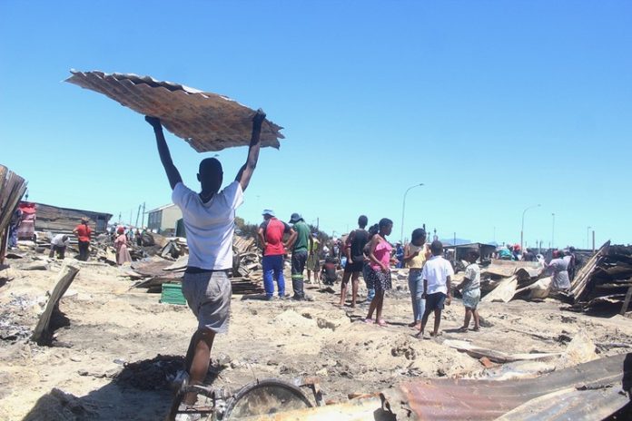 Khayelitsha fire gup 192 people were left homeless when 81 structures were destroyed in a fire in Town Two, Khayelitsha in Cape Town on Saturday morning. On Sunday, some people had begun rebuilding their homes. Photo: Masixole Feni
