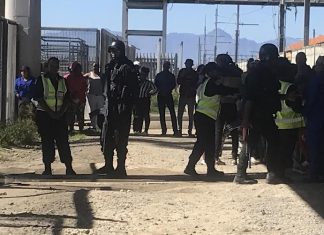 Police and onlookers at the former Philippi train station where Loyiso Nkohla was shot dead during a meeting on Monday. Photo: Tariro Washinyira